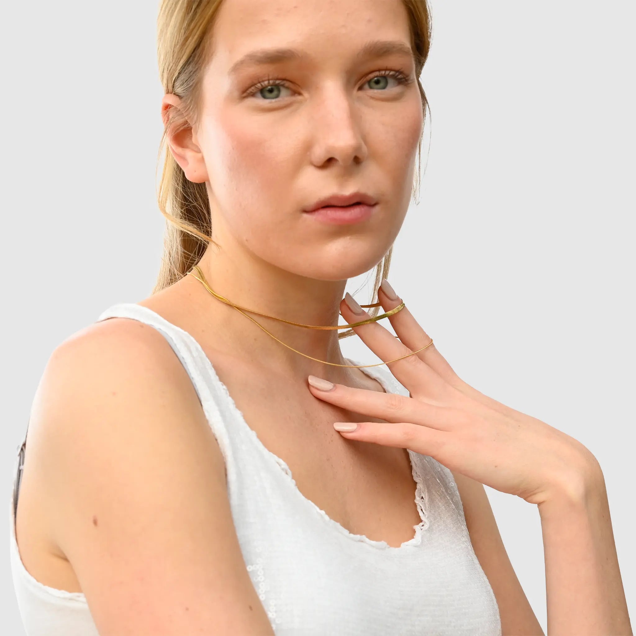 Wasserfester Layering Halskette Choker. Goldschmuck am weiblichen Modell. Von der Marke 1887Gem.