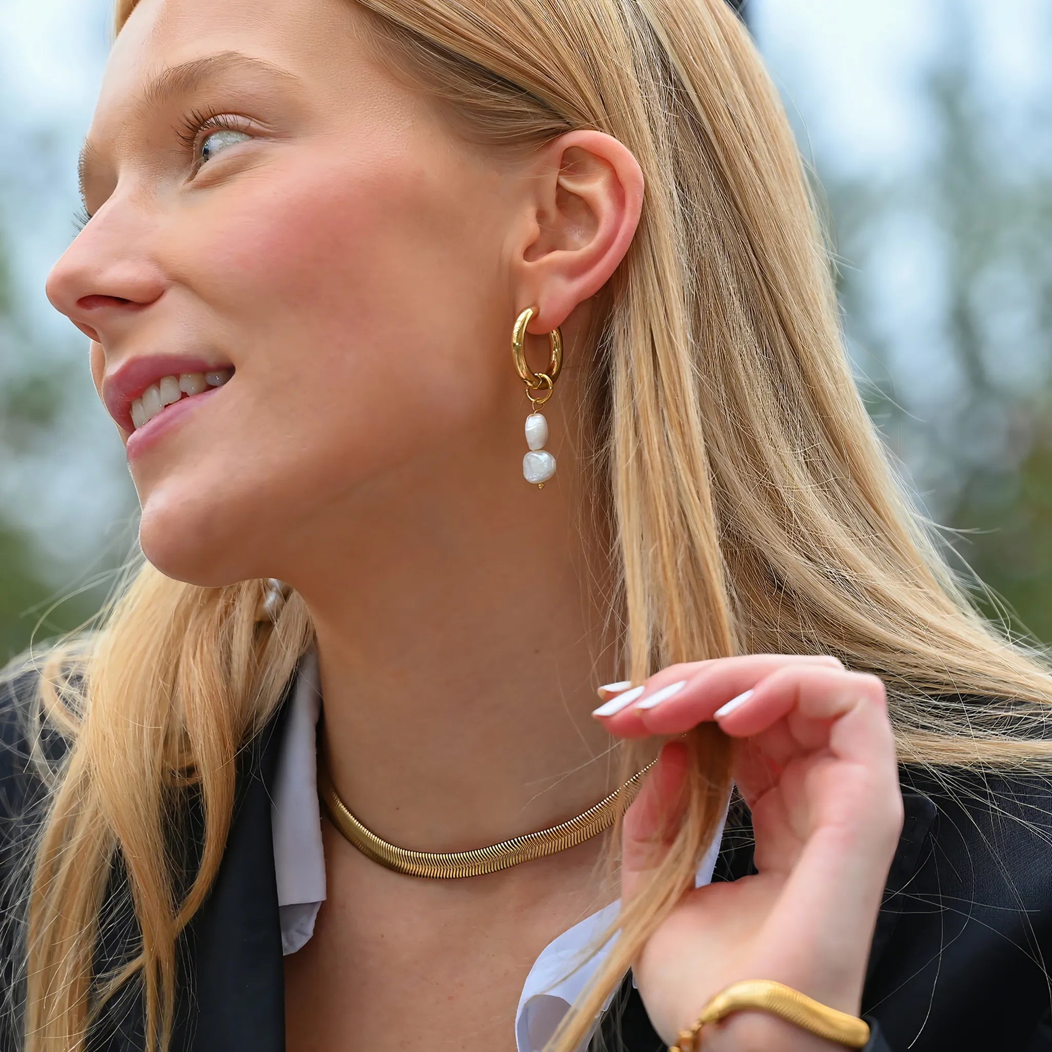 Perlen Ohrringe Gold mit zwei echten Zuchtperlen getragen am Ohr einer jungen Frau. Sanft zur Haut, wasserfest.