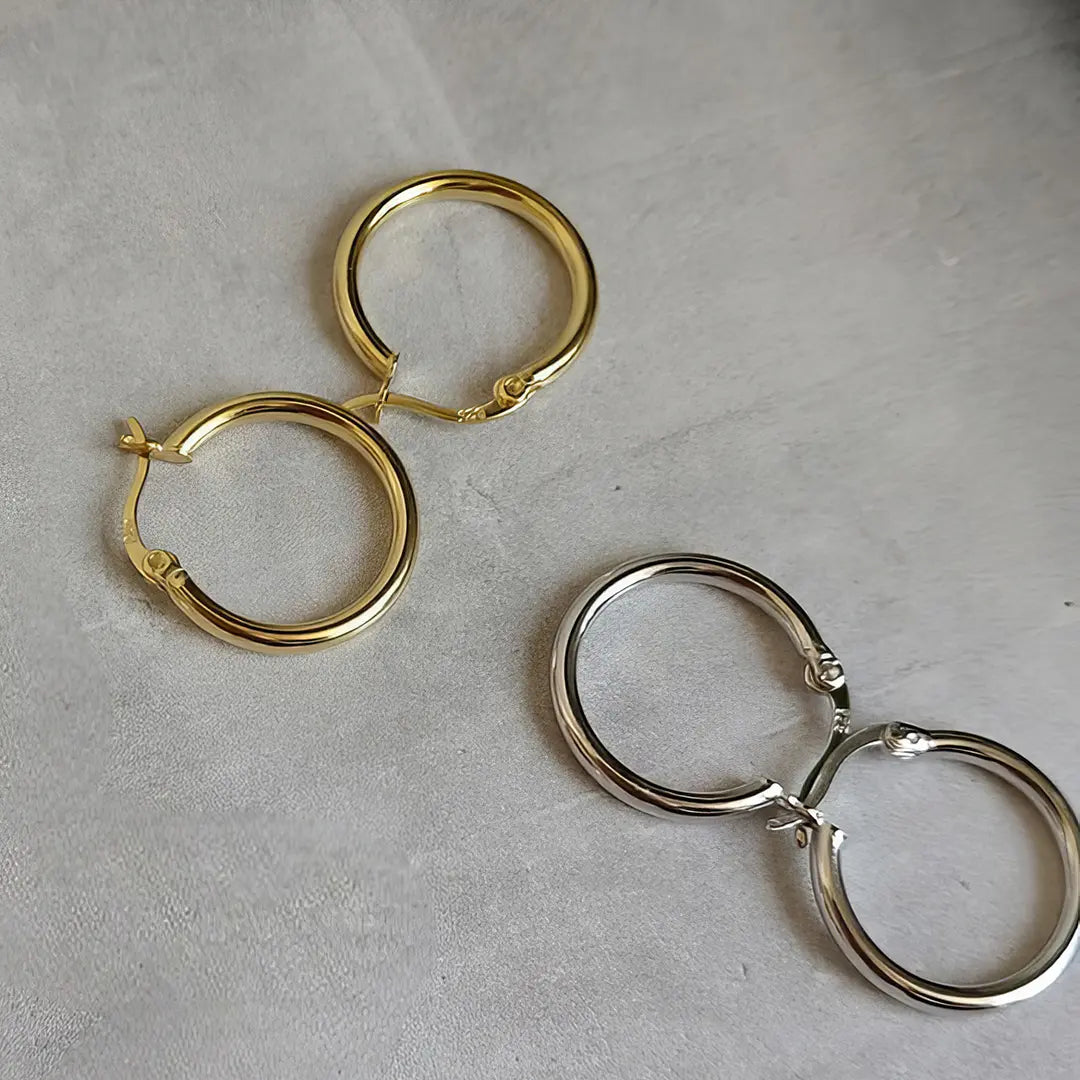 Silberohrringe aus 925 Sterlingsilber auf Beton liegend.