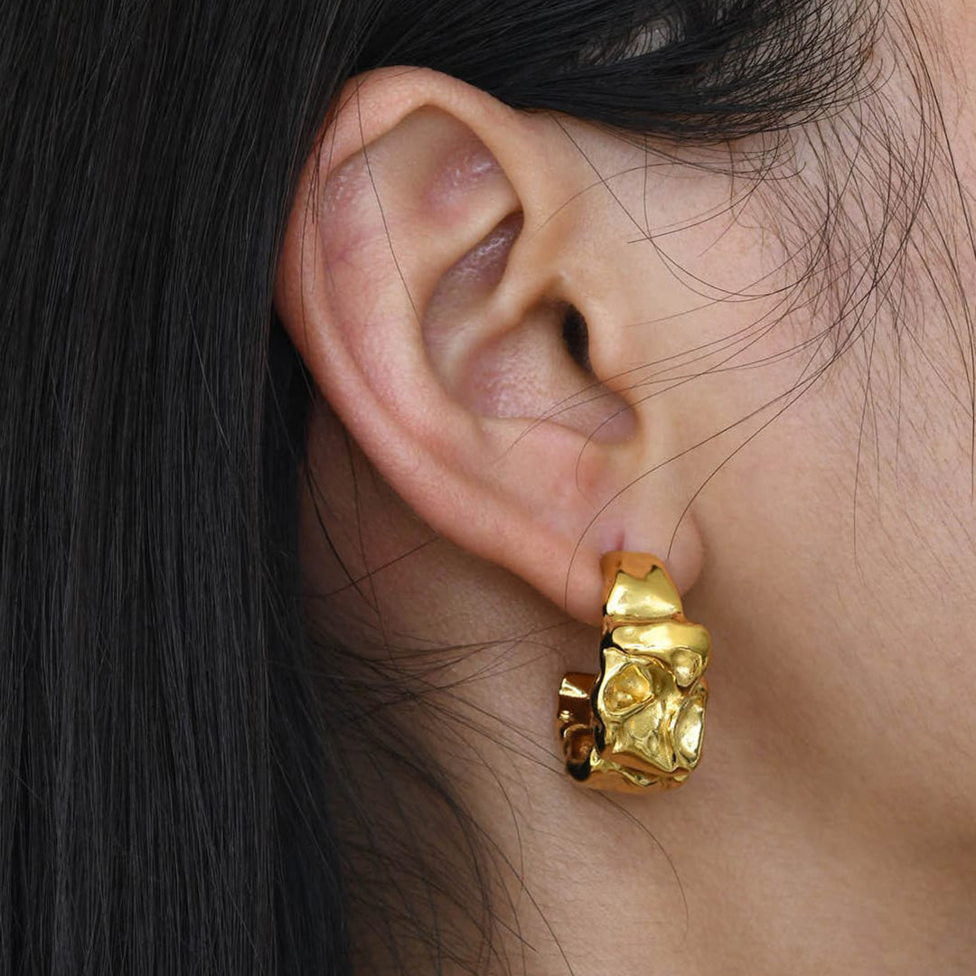 Ein Fashion Model trägt zauberhafte, wasserfeste Ohrringe für Damen und Beauties als Goldschmuck des Schmuck Online Shops 1887Gem. Das Basismaterial ist hochwertiger, langlebiger Edelstahl, der mit 18K Gold überzogen ist.