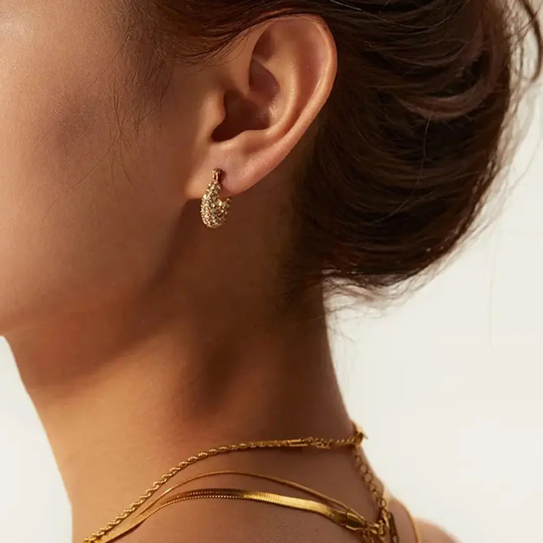 Ein bruenettes Model zeigt small Hoops Ohrringe Gold.