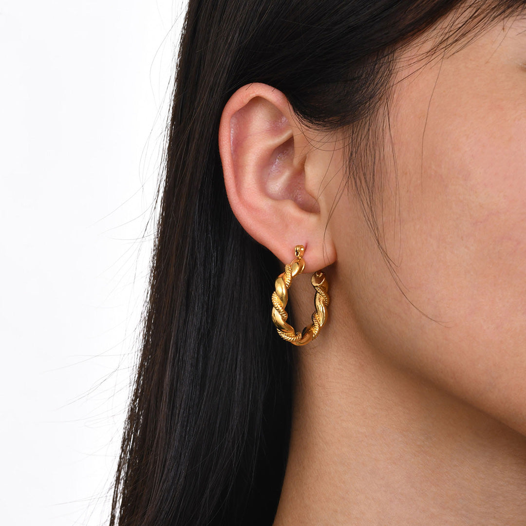 Ein Model trägt wasserfeste Ohrringe als zauberhaft schöner Goldschmuck für Damen aus dem Hause 1887Gem.com Das Basismaterial ist hochwertiger und langlebiger Edelstahl, der mit 18K Gold überzogen ist.