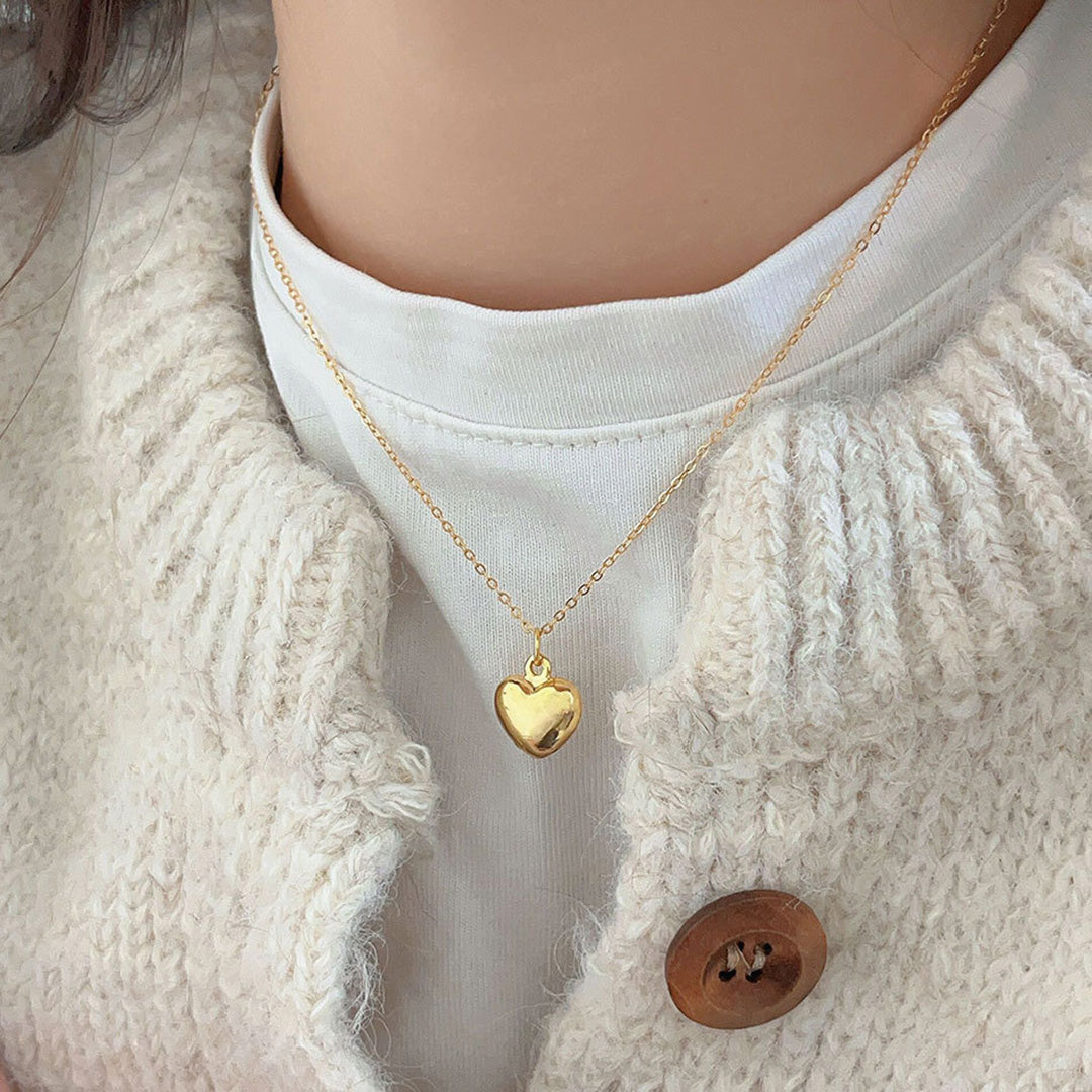 Eine vergoldete Silber Halskette wird von einem Model getragen. Der wunderschöne Silberschmuck hat einen Herz Anhänger. Jetzt online kaufen!