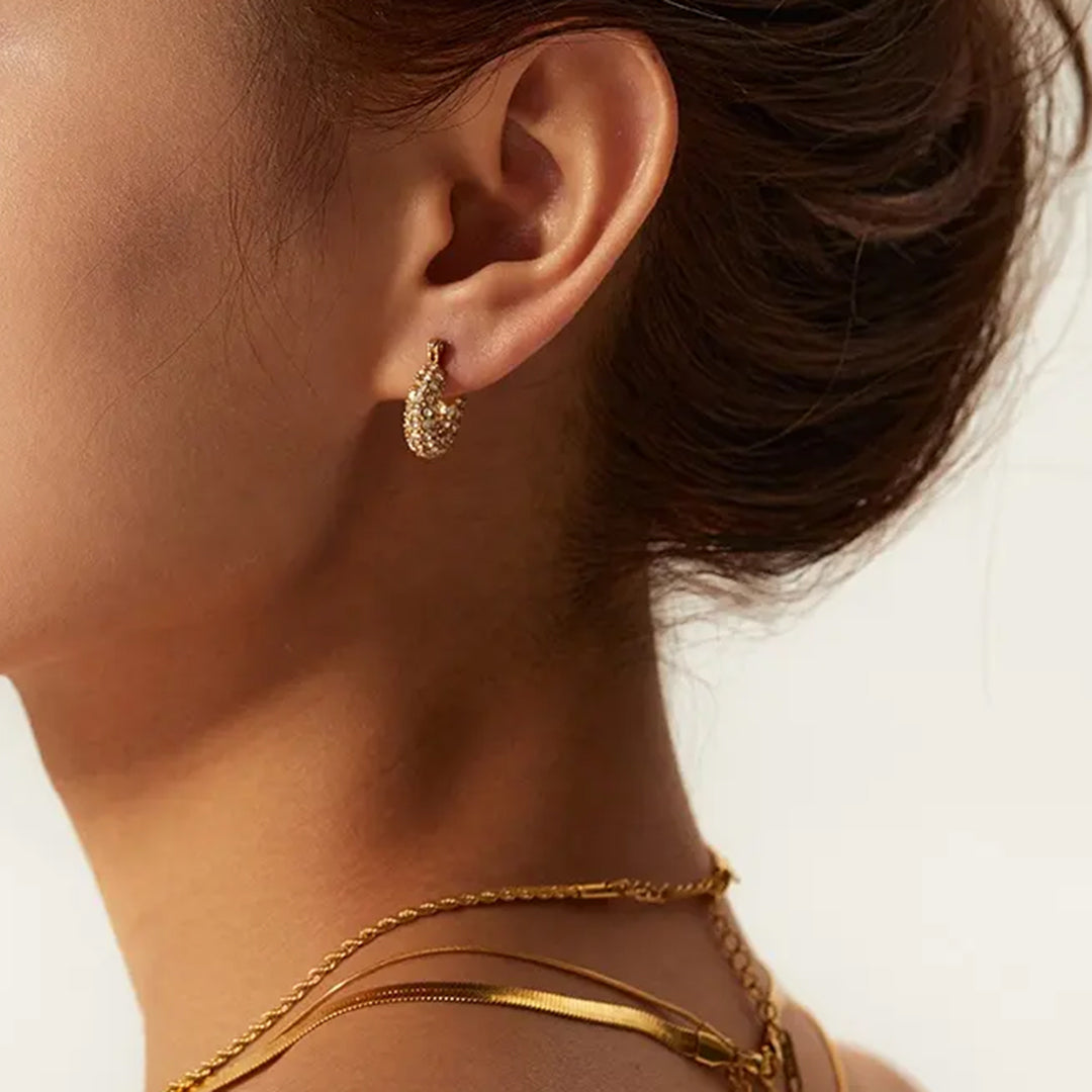 Beauty Model zeigt wasserfeste Gold Zirkonia Ohrringe und wasserfeste Halsketten vom 1887Gem Onlineshop. Jetzt online kaufen.